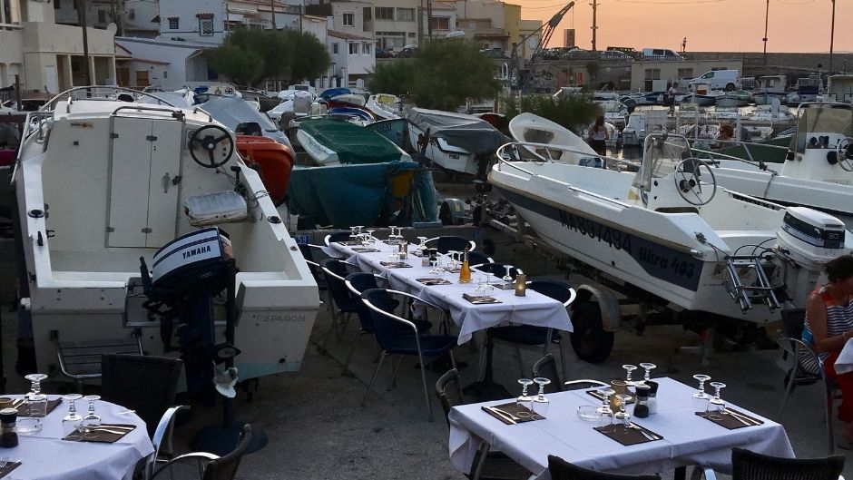 Marseille restaurant tables surrounded by parked boats