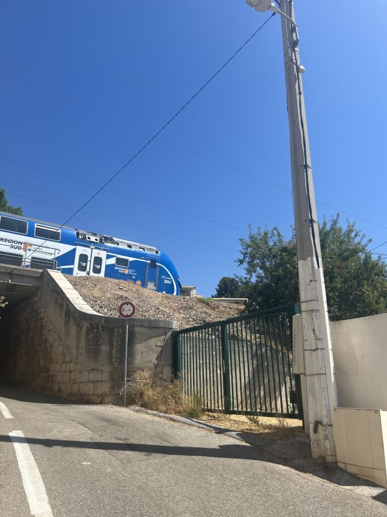 A Train passing above our Shack by the Sea to the right of the road